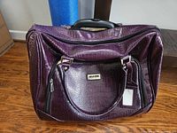 Front view showing overall design, color, texture, brand plate, front pocket, handles