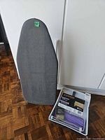 Paint kit package and ironing board standing upright