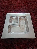 Top view of square segmented stainless steel dish showing three compartments