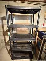 Front view of full shelving unit showing five black plastic shelves