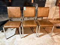Front view of three matching Liberty metal and vinyl chairs