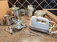 Entire lot arranged on countertop showing mixer, utensils, canisters, jar, pitcher