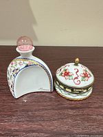 Front view of perfume bottle and trinket box showing floral patterns, stopper, and Heaven signature
