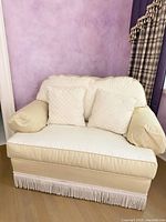 Front view showing upholstery, cushions, arms, fringe