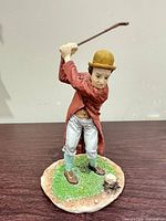Front view of golfer figurine showing pose, colors, and attached base