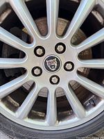 Jaguar alloy wheel close-up showing lug nuts and logo hub