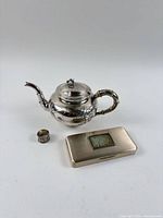 Group shot of all three items: teapot, box, napkin ring