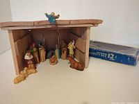 Full view of wooden stable with all figurines arranged; box at right