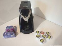 Complete lot: coffee maker, sealed pack of reusable capsules, seven pods