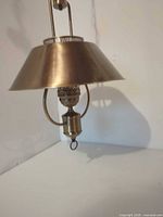 Close-up of brass hanging lamp shade, socket, and finial ring