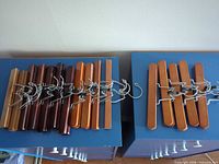 All 16 wooden hangers laid out showing color variety and hooks