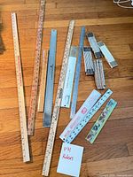 Group of mixed rulers on hardwood floor