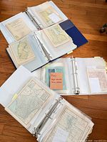 Binders opened showing multiple sleeves with individual small maps