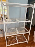 Front view showing full rack structure, four wire shelves and casters