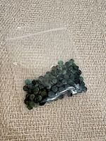 Bag containing many small green rondelle beads