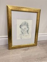 Framed portrait standing against wall