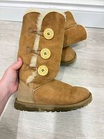 Side view showing three buttons, suede surface, shearling trim