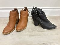 Both pairs of ankle booties side by side, tan and black