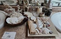 Shells and coral on plate and in wooden bowl with figurine