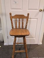 Front view of oak swivel bar stool