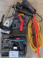 Group shot showing all items: Ryobi drill set in case, Hoover Brush Vac, Black & Decker glue gun, extension cord, red tool