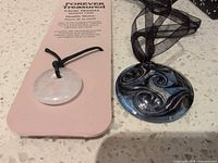 Both pendants side by side, showing cords and card