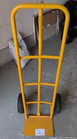 Full front view of yellow hand truck standing upright