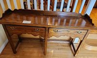 Front view of oak console table showing gallery edge top, drawers and legs