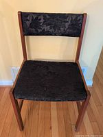 Front view of one chair showing overall design, upholstery pattern and wood frame