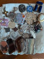 Group shot showing variety of pendants including coins, crosses, glass and stone items