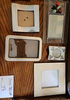 Five small to medium metal frames in various shapes and finishes