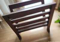 Wooden slat magazine rack standing on floor
