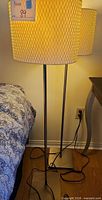 Full view of one floor lamp showing cream drum shade, twin metal poles, brushed nickel finish