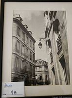 narrow street scene photograph in black frame with mat