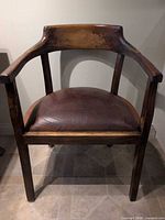 Front view of wood armchair showing overall design and leather seat