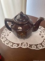 Full view of teapot on lace mat