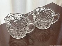 Creamer and sugar bowl side by side showing pattern and handles