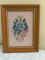 Full view of framed floral cross-stitch artwork front