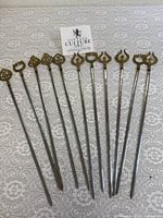 Full set of 11 skewers laid out on lace surface