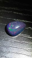 Pear-shaped black opal showing multicolor play-of-color