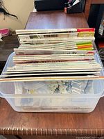 Stack of magazines inside clear plastic bin