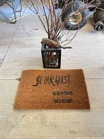 Coir doormat on floor showing full text and metal holder behind