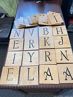 Front view of multiple wooden letter tiles laid out showing letters and finish