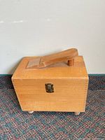 Exterior of light brown wooden shoeshine box with footrest