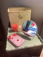 All items grouped: mirror, first aid tin, two candles, fabric cube