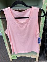 Front view of pink tank top on hanger showing sequins and overall design