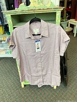 Front view of lilac Tilley short-sleeve button-up shirt on hanger