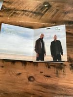 Open booklet showing photo of two men on a beach