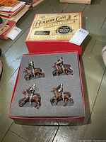 Four mounted soldier figures in foam insert within red Hollow Cast Collection box