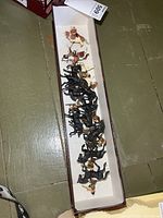Mounted figures inside maroon tray